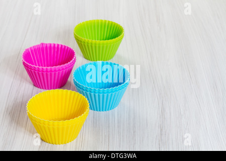 Farbenfrohe Silikon Cups auf hölzernen Hintergrund backen. Stockfoto