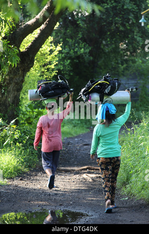 Balinesischen Frauen tragen Tauchflaschen Tauchen zu einem Tauchplatz, Portier-Service bereitgestellt, wenn in Tulamben, Ost Bali Tauchen Stockfoto