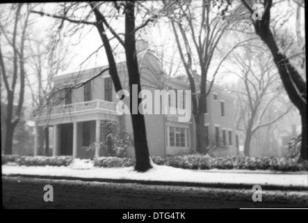 Dieses historische Foto zeigt das nationale Hauptquartier von Phi Delta Theta im Winter um 1935. Das Bild fängt die ruhige Schönheit des Gebäudes während der Schneesaison ein und unterstreicht seine Architektur. Stockfoto