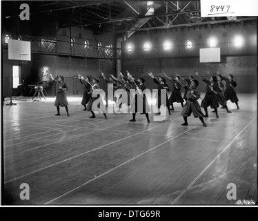Ein Foto von Frauen aus dem Jahr 1908, die in einer Ausstellung am Herron Gymnasium die erste Position des Wands spielen. Das Bild zeigt Gymnastik und Frauensportunterricht an der Miami University in Oxford, Ohio. Stockfoto