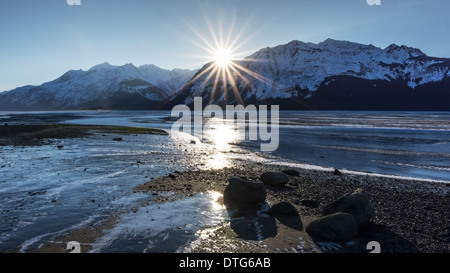 Sunburst an einem Strand aus die Chilkat Inlet in der Nähe von Haines Alaska bei Sonnenuntergang. Stockfoto