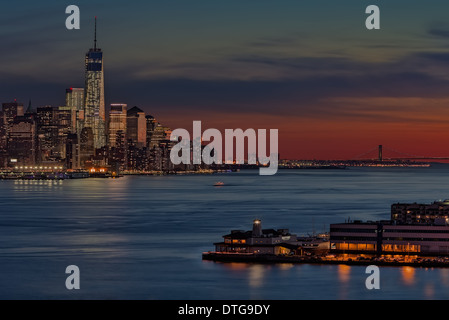 Die untergehende Sonne verschönert die unteren Skyline von New York City. Umgeben von anderen NYC Wolkenkratzer ist der New Freedom Tower Stockfoto