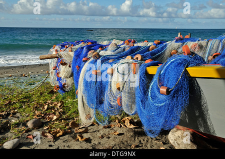 Angelboot/Fischerboot und bunte Netze an einem Strand in der Nähe von Gouyave, Grenada. Stockfoto