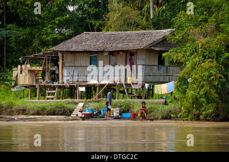 Dorfbewohner, die Wäsche am Flussufer, Kinabatangan Fluss, Sabah, Malaysia Stockfoto