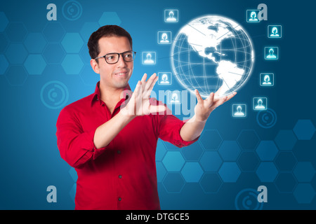Business-Mann im roten Hemd mit futuristischen global Network-marketing-Schnittstelle von Hologramm Erde mit männlichen weiblichen Symbolen auf blau. Stockfoto