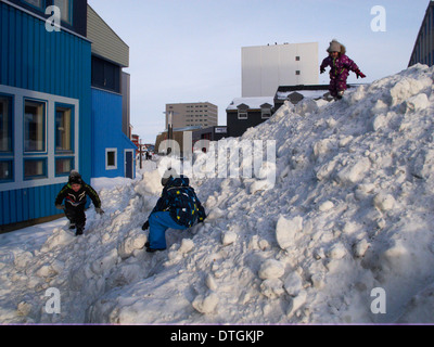 Nuuk-Center auf der Hauptstraße, Ung jungen und Mädchen spielen auf einem Berg von Schnee. Stockfoto