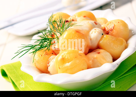 Schüssel mit Kartoffeln garniert mit geschmolzenem Käse und butter Stockfoto