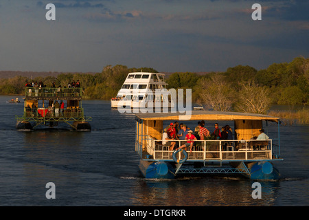 Kreuzfahrt entlang der Victoria Falls an Bord der "African Queen".  Andere Boote Segeln in den Sambesi. Nehmen Sie eine Bootsfahrt bei Sonnenuntergang Stockfoto