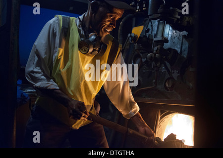 Eines der Eisenbahner der Livingstone Express Luxus Zug Kohle angetriebene Zug Lokomotive.  Der Zug stoppt. Stockfoto