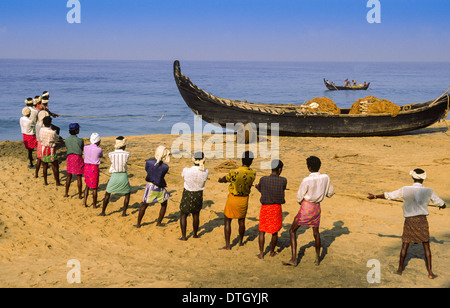 FISCHER SCHLEPPT SEINE NETZE AN EINEM STRAND VON KERALA IN SÜDINDIEN Stockfoto