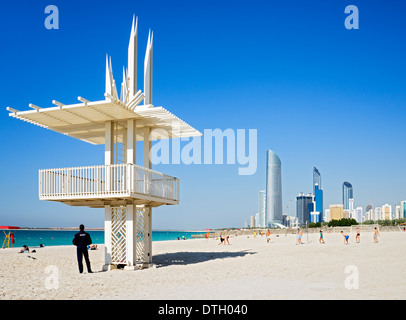 Volleyballspiel am Strand von Corniche mit Skyline in Abu Dhabi Vereinigte Arabische Emirate Stockfoto