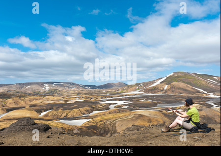 Trekking im Hochland, Frau Ruhe, weite Berglandschaft und Schneefelder, Laugavegur-Wanderweg in der Nähe von Hrafntinnusker Stockfoto