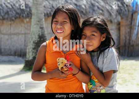 Zwei Kuna indische Mädchen hält ein kleines Stofftier in Kuna Indianer-Dorf, Nalunega, San Blas Inseln, Panama Stockfoto