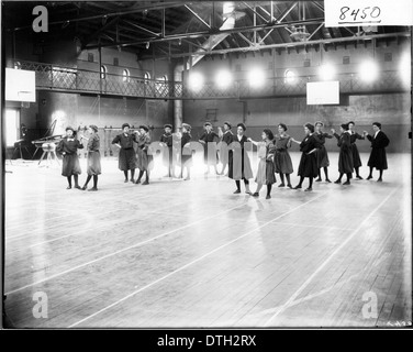 Dieses historische Foto aus dem Jahr 1908 zeigt Frauen, die einen Tanz für eine Sportausstellung im Herron Gymnasium der Miami University aufführen. Die Veranstaltung hebt die frühen Bemühungen in der Ausbildung und körperlichen Fitness von Frauen hervor und fängt einen Moment in der Entwicklung von Gymnastik und Sport für Frauen während dieser Zeit an der Universität ein. Stockfoto
