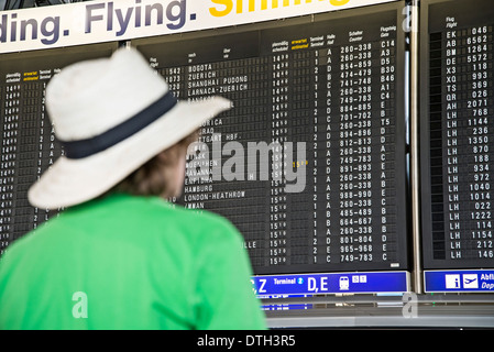 Teenager auf der Suche auf einer Anzeigetafel am Flughafen Frankfurt. Stockfoto