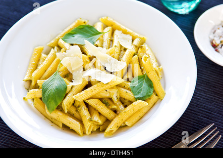 Penne in Pesto-Sauce mit geriebenem Parmesan obenauf Stockfoto