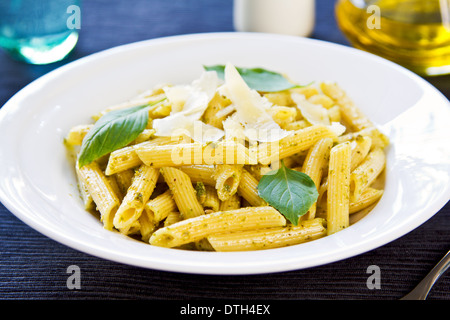 Penne in Pesto-Sauce mit geriebenem Parmesan obenauf Stockfoto