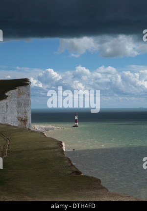 Ein Blick auf die Beachy Head Leuchtturm von den Severn-Schwestern. Mit fernen blauen Himmel und flauschige Wolken, aber Sturm Wolken. Stockfoto