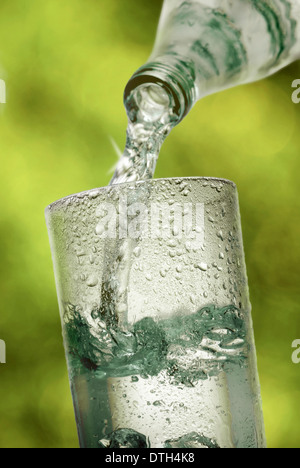 Mineral Wasser in ein Glas gegossen wird. Stockfoto