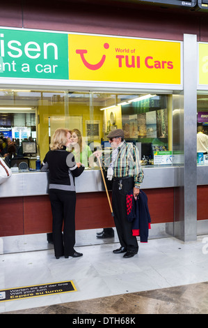 Ein paar an einem Auto mieten Schalter im Ankunftsbereich auf Teneriffa Süd Flughafen, Kanarische Inseln, Spanien. Stockfoto