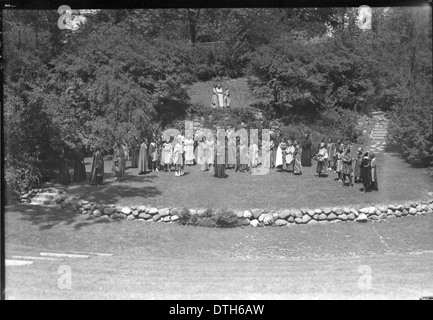 Dieses Foto aus dem Jahr 1934 zeigt das Western College in Oxford, Ohio, das den Tree Day feiert, eine Veranstaltung zur Förderung des Umweltbewusstseins und der Aktivitäten im Freien. Die Schüler werden in historischen Kostümen gesehen, die eine Open-Air-Theateraufführung durchführen. Das Foto zeigt das Wesen der Frauenerziehung und die historische Bedeutung der Traditionen der Hochschule. Stockfoto