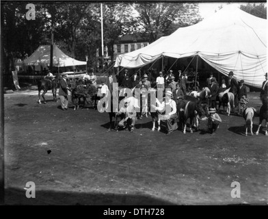 Ein historisches Foto von 1912, das Männer mit Ponys auf der Oxford Street Fair zeigt. Das Bild fängt einen Moment des Straßenlebens während des frühen 20. Jahrhunderts ein und veranschaulicht die Aktivitäten und Atmosphäre der Messe. Stockfoto