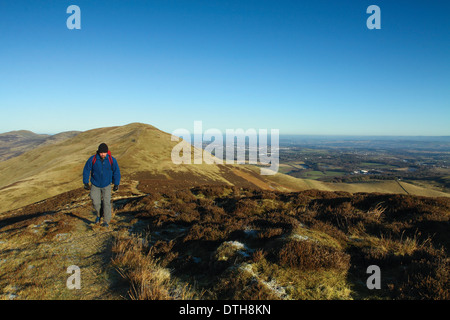 Ein Walker Klettern Carnethy Hügel mit Blick auf Turnhouse Hill und Edinburgh von Carnethy Hill, The Pentland Hills, Lothian Stockfoto