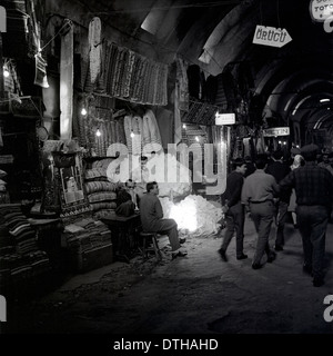 1950er Jahren und eine historische Bild aus Orucu, Istanbul, Türkei zeigt einen Straßenmarkt beleuchtet in der Nacht wo viele Teppiche verkauft werden. Stockfoto