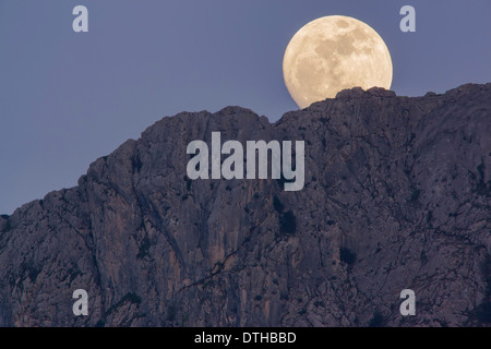 Echte Vollmond über Bergen über Serra d'Alfàbia Berg in der Abenddämmerung. Tramuntana Hügel, Sóller Bereich, Mallorca, Balearen, Spanien Stockfoto