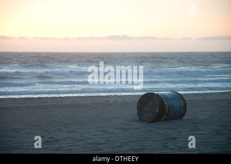Eine leere Metall-Trommel am Strand bei Sonnenuntergang Stockfoto