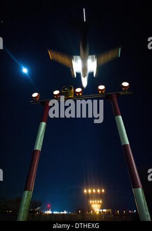 Berlin, Deutschland. 9. Februar 2014. Ein Flugzeug fliegt vorbei an der Fackel-Pfad in den späten Abend am Flughafen Tegel in Berlin, Deutschland, 9. Februar 2014. Foto: Christoph Schmidt/Dpa/Alamy Live News Stockfoto