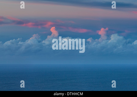 Cumulus-Wolken und rote Cirruswolken über dem Meereshorizont bei Sonnenuntergang. Blick vom Mallorca, Balearen, Spanien Stockfoto