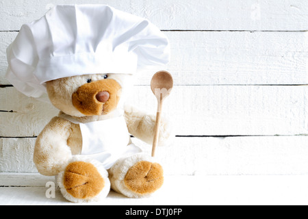 Teddybär in Koch Hut mit Löffel abstrakten Hintergrund Essenskonzept Stockfoto