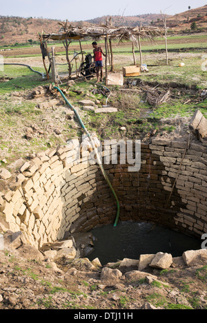 Pumpen von Wasser aus einem Brunnen in der indischen Landschaft für Reis Reisfeld Bewässerung. Andhra Pradesh, Indien Stockfoto