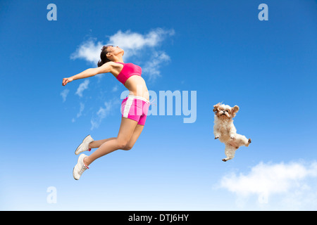 junge Frau und Hund in den Himmel springen Stockfoto