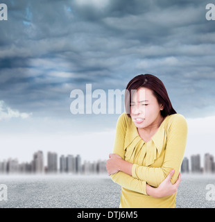 Junge Frau Schaudern und straffen Körper bei schlechtem Wetter Stockfoto