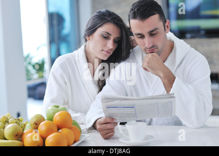 Glückliches Paar Zeitunglesen in der Küche beim Frühstück Stockfoto