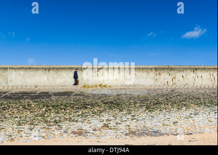 Ein Mann zu Fuß entlang dem Deich auf Canvey Island in Essex. Stockfoto