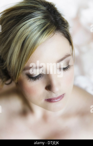 Ein Porträt einer jungen Frau mit blonden Haaren vor einem weißen Hintergrund Nahaufnahme ihres Gesichts England Stockfoto