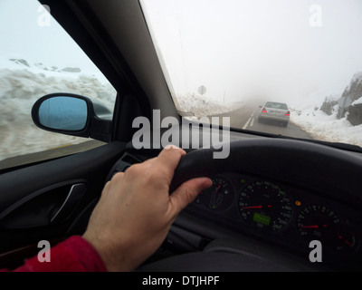 Des Fahrers Hand am Lenkrad während der Fahrt im Schnee Stockfoto