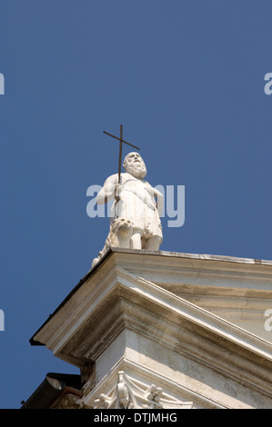 Statue eines Mannes mit einer religiösen Kreuz auf einem Dach, Detail. Stockfoto