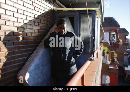 Madrid, Spanien. 19. Februar 2014. 29-jährige spricht Maria Menendez Melendez durch das Telefon auf der Terrasse, wie sie wartet darauf, von ihrem Haus in Madrid, Spanien, Mittwoch, 19. Februar 2014 geräumt werden. Maria Menendez Melendez 29-jährige aus der Dominikanischen Republik lebt seit acht Jahren mit seinem Partner Carlos und ihren zwei Kindern, Raquel ConcepciÃƒÂ³n Menendez 9 jährige und Jean Carlos Concepcion Menendez 6 Jahre alt, in einer Wohnung Eigentum von '' La CAM-Sabadell'' mit denen sie vertraglich einer Hypothek, die für 6 Jahre nicht gezahlt haben. Bevor er arbeitete arbeitslos Maria als ein kitchener Stockfoto