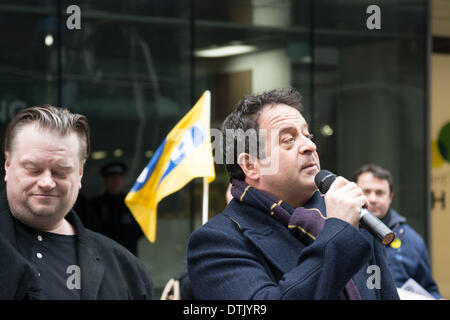 ATOS Hauptsitz, London, UK, 19. Februar 2014. Schauspieler und Aktivist Mark Thomas spricht außen ATOS Hauptsitz in London, das Unternehmen Umsetzung der Arbeit Fähigkeit Bewertungen zu protestieren. Aktivisten für die Abschaffung der Arbeit Fähigkeitsbewertung genannt und erklärt, dass ein qualifizierter Arzt, im Idealfall der Hausarzt, regelmäßig sieht und behandelt die Kranken oder behinderten Person in Frage, die einzige Person in der Lage ist zu entscheiden, ob ein Individuum für die Arbeit fit ist. Bildnachweis: Patricia Phillips/Alamy Live-Nachrichten Stockfoto