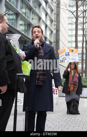 ATOS Hauptsitz, London, UK, 19. Februar 2014. Schauspieler und Aktivist Mark Thomas spricht außen ATOS Hauptsitz in London, das Unternehmen Umsetzung der Arbeit Fähigkeit Bewertungen zu protestieren. Aktivisten für die Abschaffung der Arbeit Fähigkeitsbewertung genannt und erklärt, dass ein qualifizierter Arzt, im Idealfall der Hausarzt, regelmäßig sieht und behandelt die Kranken oder behinderten Person in Frage, die einzige Person in der Lage ist zu entscheiden, ob ein Individuum für die Arbeit fit ist. Bildnachweis: Patricia Phillips/Alamy Live-Nachrichten Stockfoto