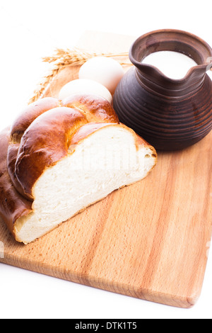 Frischen Laib Challah mit Milch und Eiern auf dem Holzbrett Stockfoto