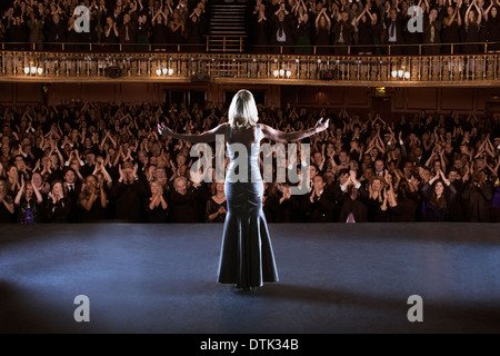 Performer stehen mit auf der Bühne im Theater ausgestreckten Armen Stockfoto