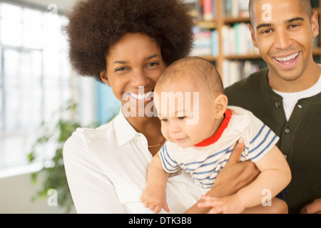 Familie lächelnd zusammen im Wohnzimmer Stockfoto