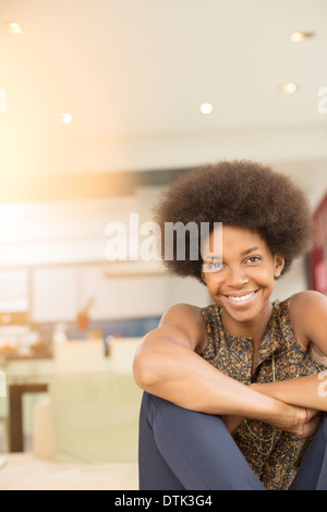 Lächelnde Frau sitzen im Wohnzimmer Stockfoto