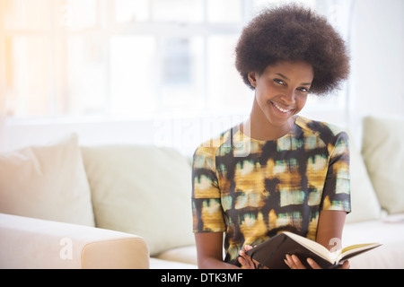 Frau liest auf sofa Stockfoto