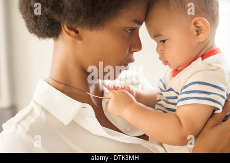 Baby Junge spielt mit Mutters Halskette Stockfoto